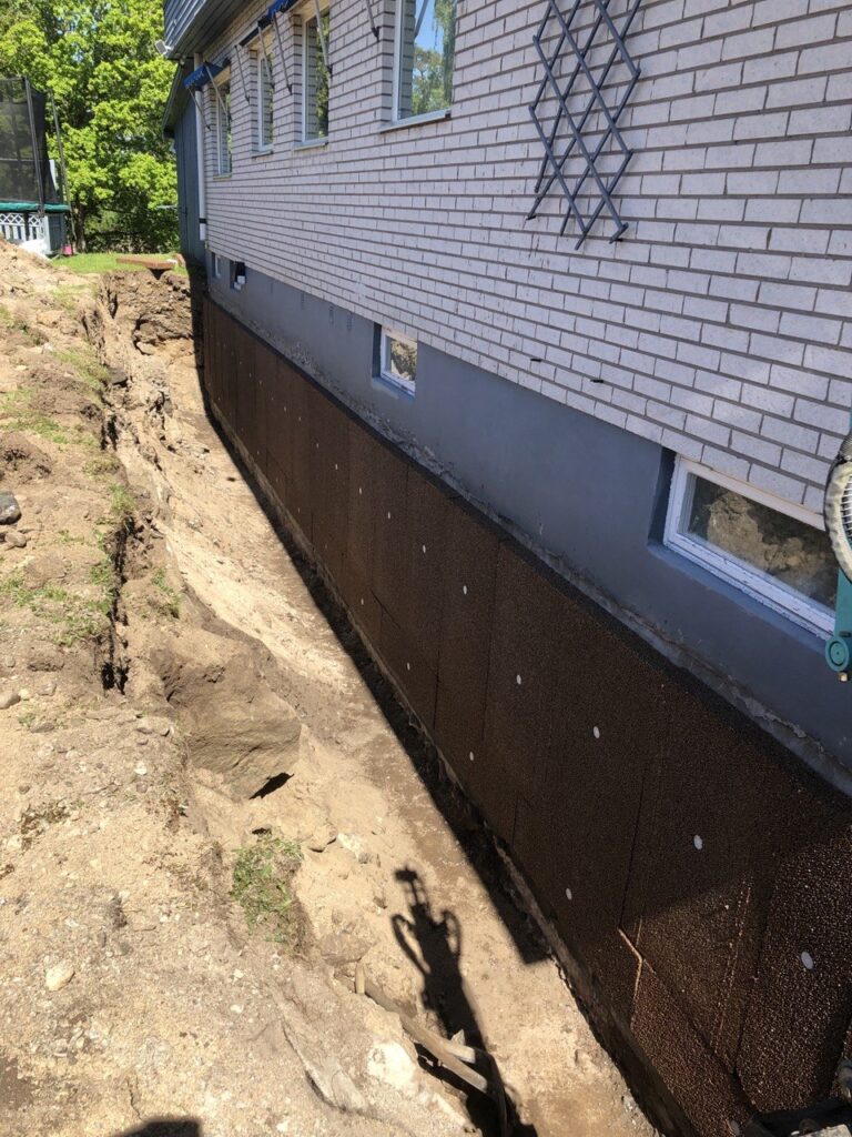 Dräneringsskiva installerad längs husgrund vid dräneringsarbete i Lilla Edet.