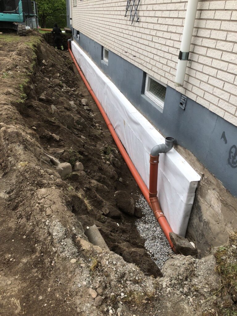 Dagvattenrör installerade vid husgrund under dräneringsarbete i Lilla Edet.