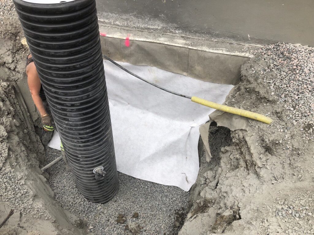 Installation av pumpbrunn vid husgrund för förbättrad vattenhantering i Nödinge.