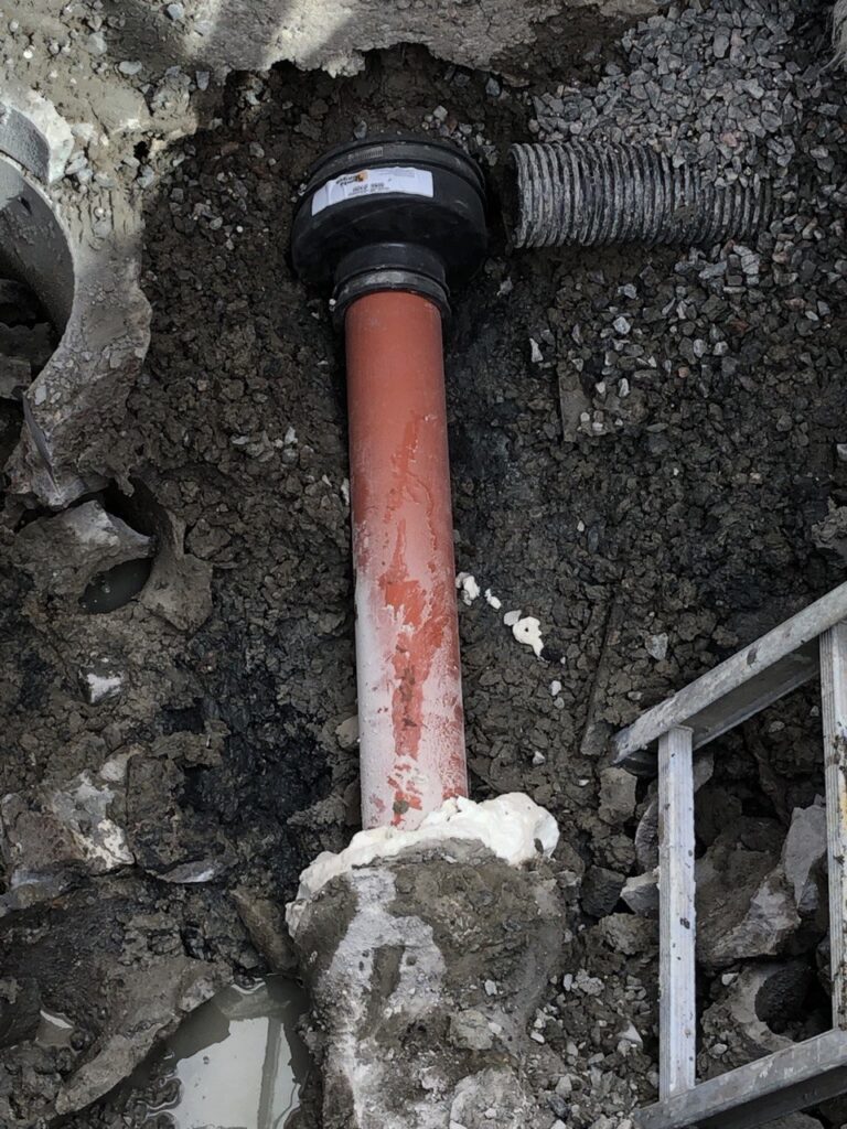 Anslutning av dräneringsledning till pumpbrunn under installation i Nödinge.