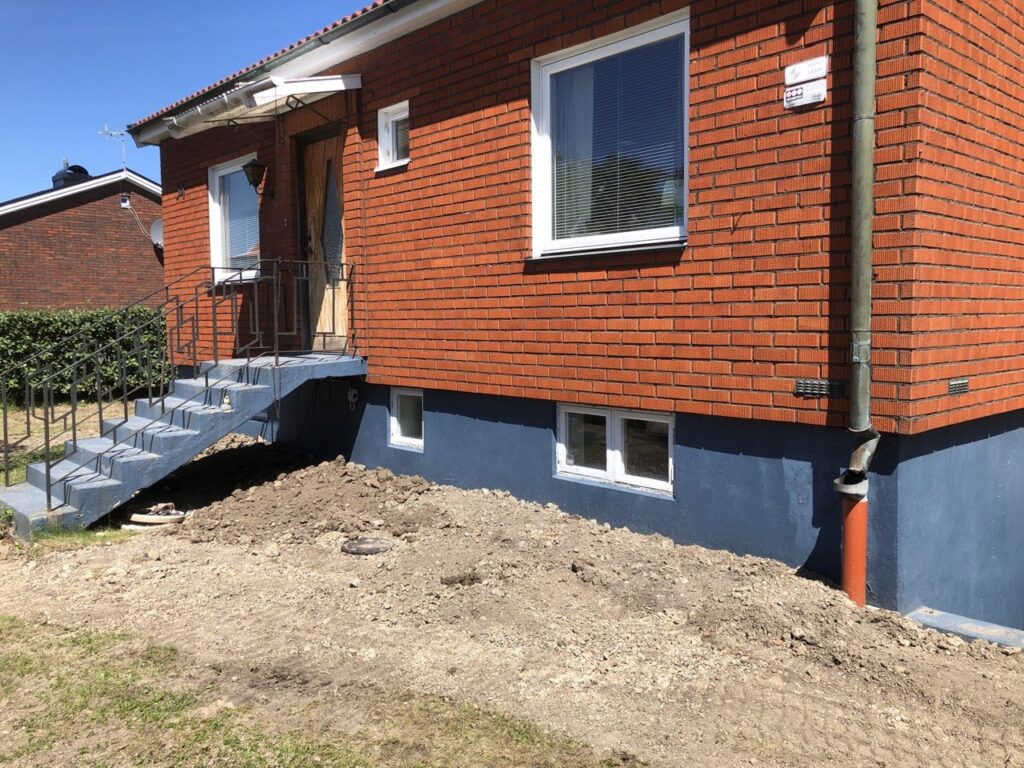 Återställd mark på framsidan av huset efter slutfört dräneringsarbete vid villa i Vänersborg.