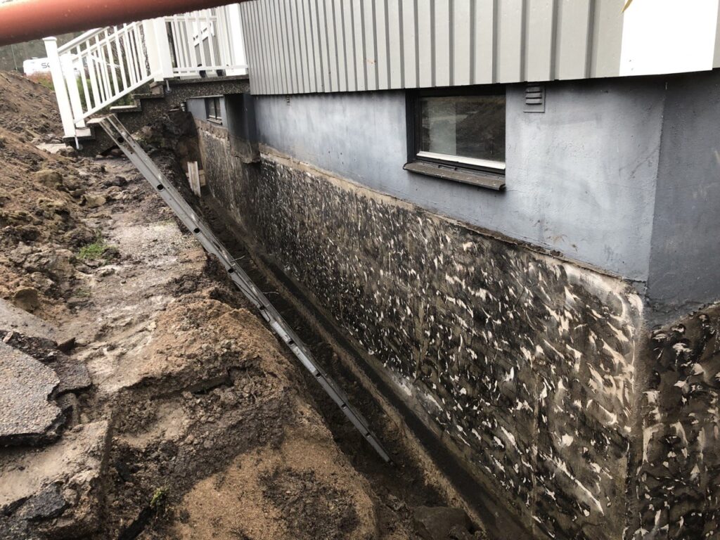 Rengjord husgrund inför montering av dräneringsskivor.